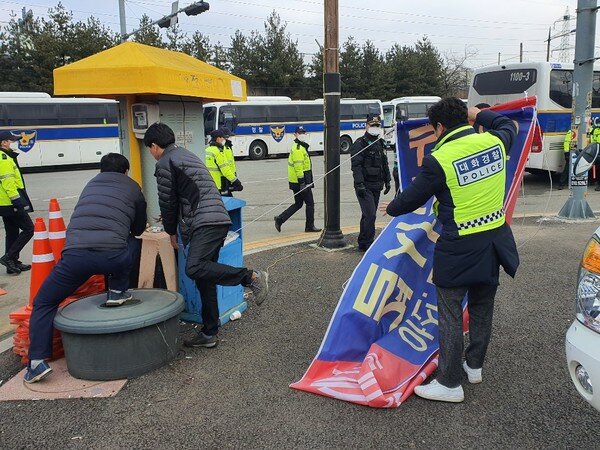 31일 오전 충남 아산시 사래마을 입구에서 주민들과 경찰이 '우한 코로나 바이러스 전세기 아산.친천 격리수용 결사반대'라고 적혀있던 플래카드를 제거하고 있다. © 뉴스1