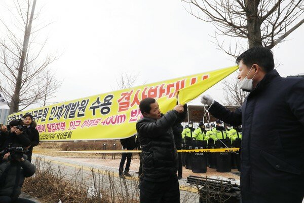 31일 오전 11시10분쯤 충북 진천군 우한 교민 수용 반대대책위원회 관계자들이 국가공무원인재개발원 교민 수용 반대를 철회하겠다며 현수막을 제거하고 있다. 2020.1.31/뉴스1